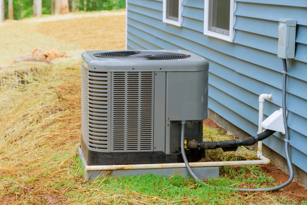 AC unit in yard outside of a house.